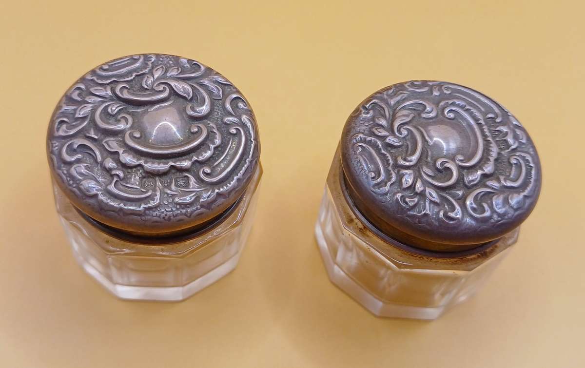 Two small marked silver and glass vanity jars lion facing left