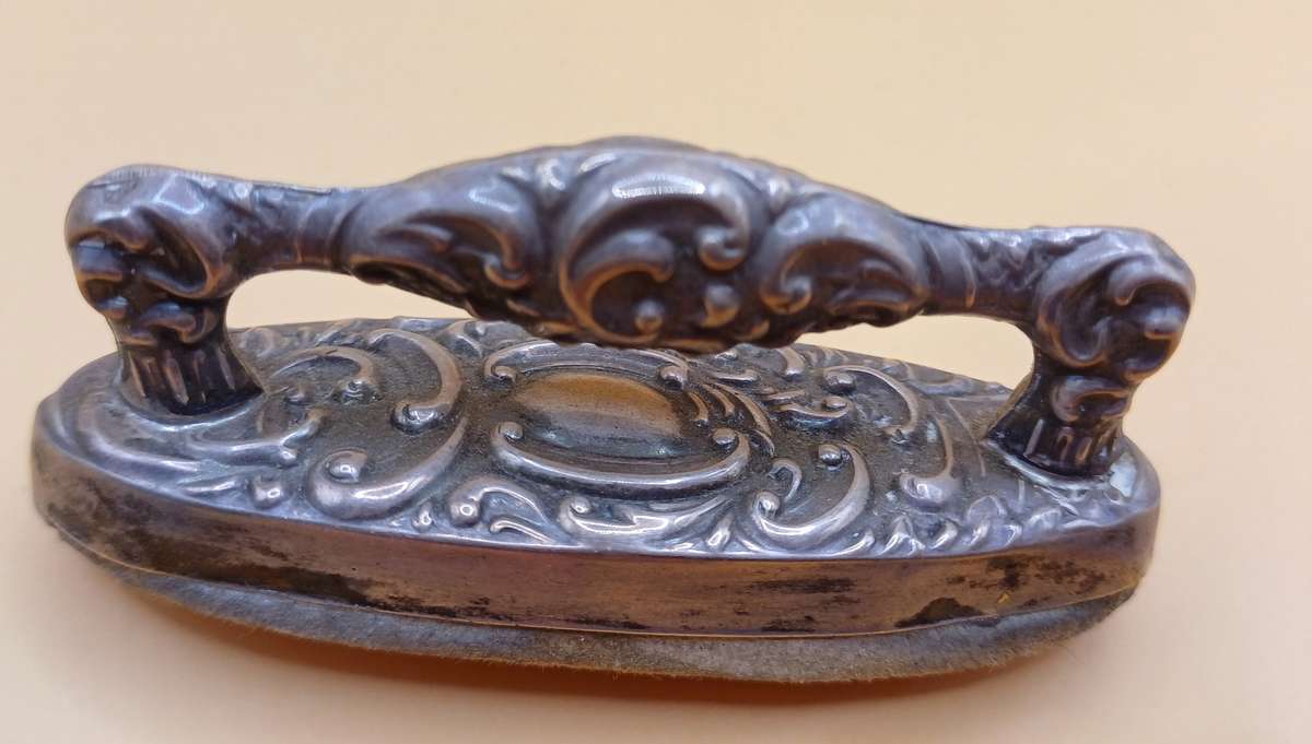 Marked silver nail buffer lion facing left