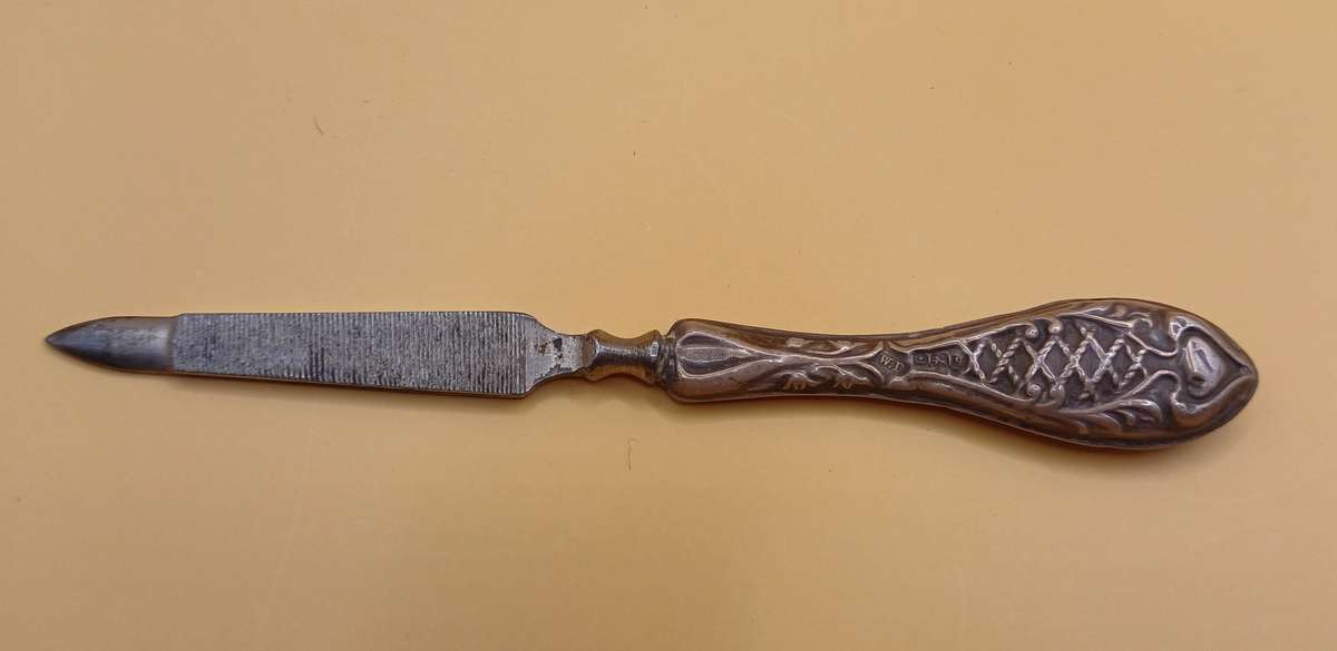 Marked silver nail file lion facing left