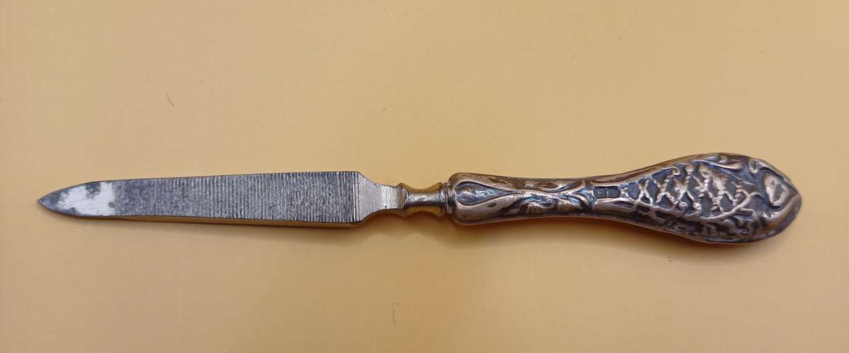Marked silver nail file lion facing left