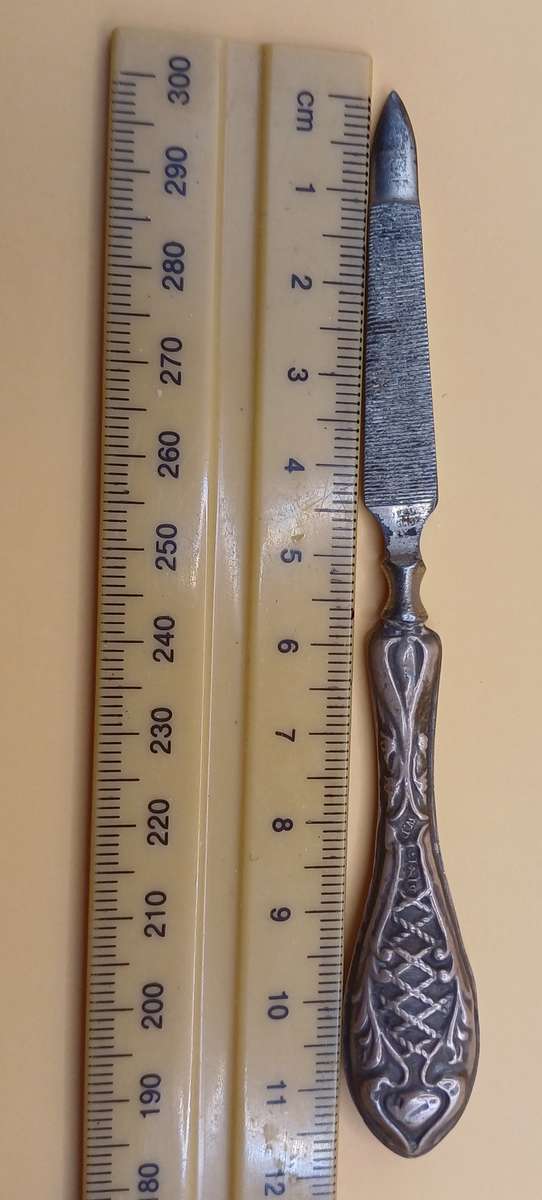 Marked silver nail file lion facing left
