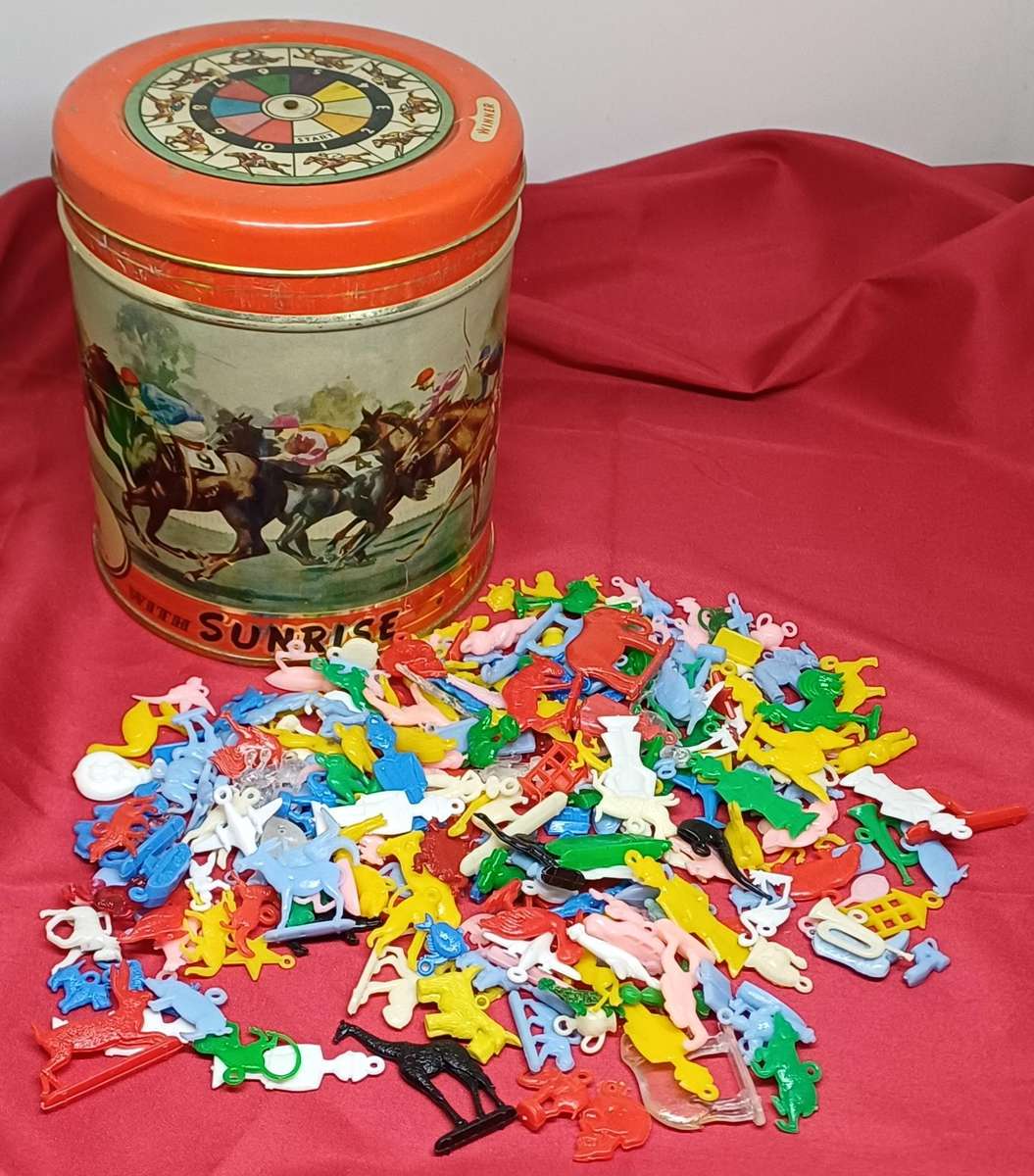 Collectable tin full of vintage plastic charms