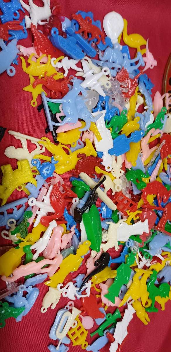 Collectable tin full of vintage plastic charms