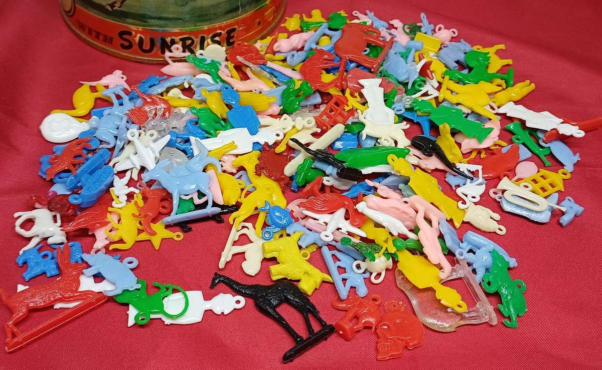 Collectable tin full of vintage plastic charms