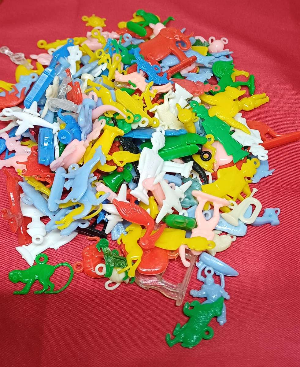 Collectable tin full of vintage plastic charms