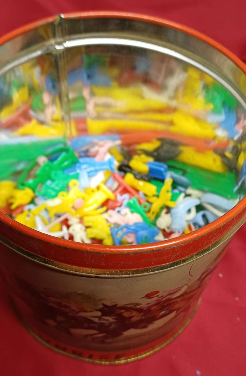 Collectable tin full of vintage plastic charms