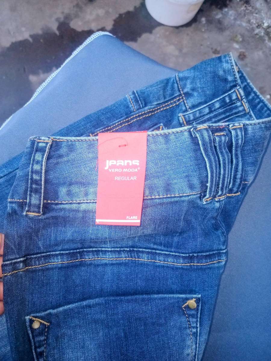 five pairs of denim jeans, including several blue washes and one black Only Jeans pair with tags,