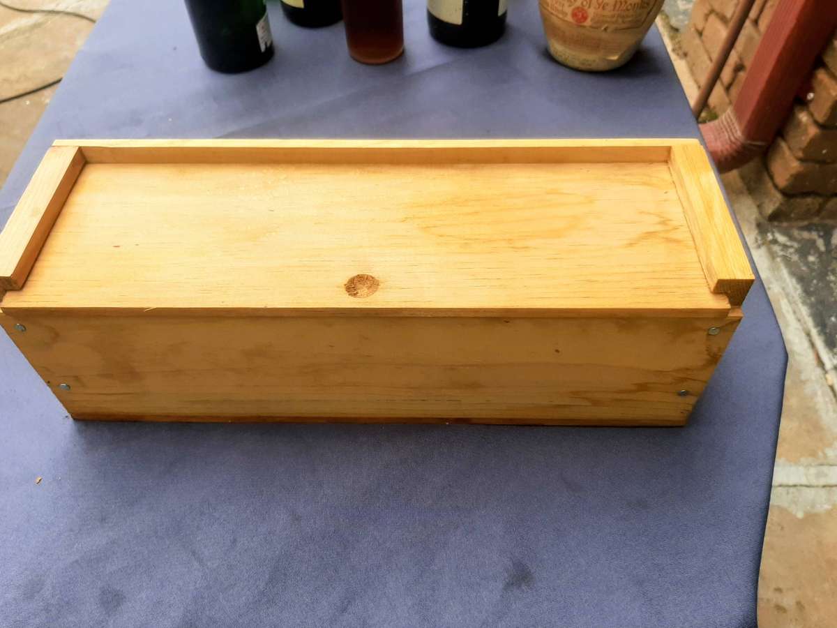 Cabernet Sauvignon, presented in a wooden gift box. The bottle is wrapped in plastic and packing