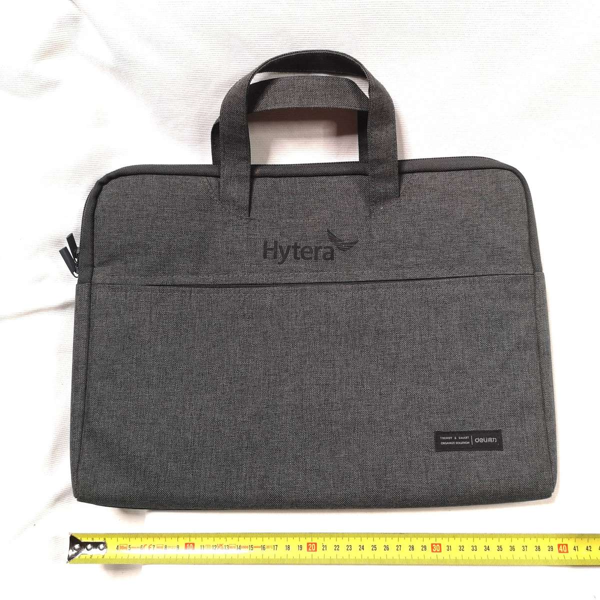 Hytera-branded laptop bag. It is a gray briefcase-style bag with a handle on top and a zipper
