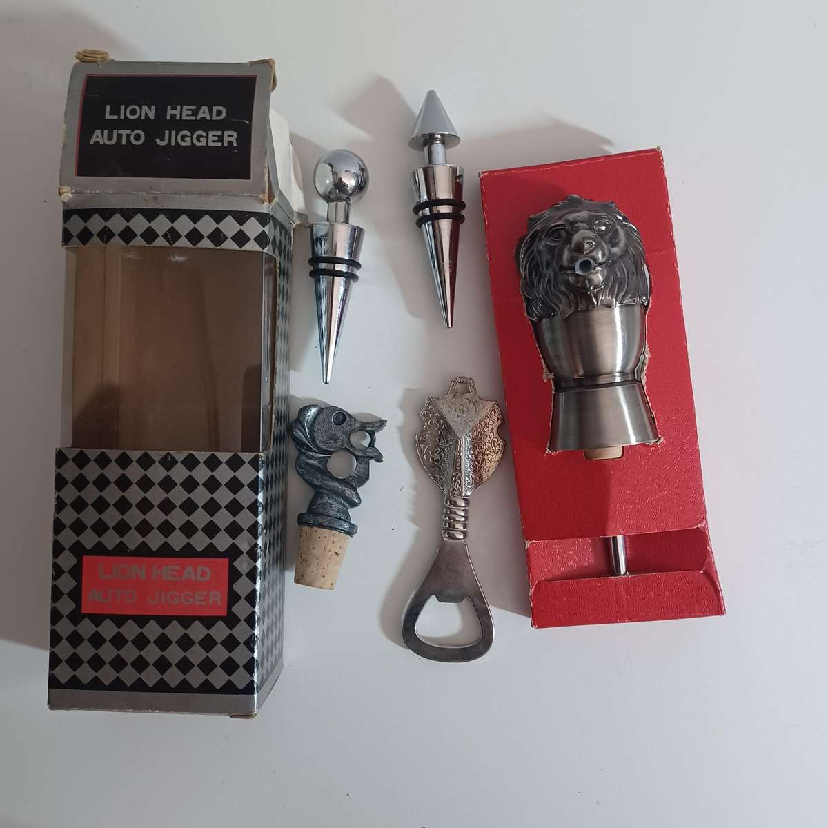 Vintage collection of bar accessories including: Lion Head Auto Jigger, Wine Stoppers