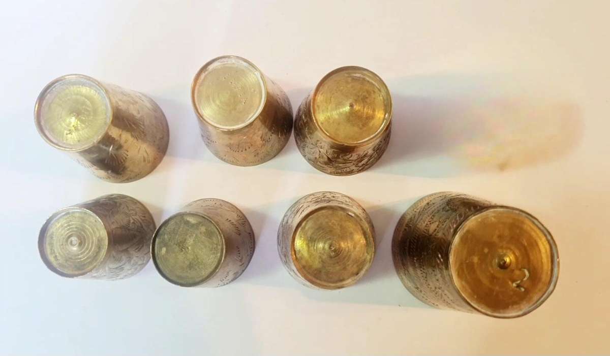7 brass shot glasses. Various sizes