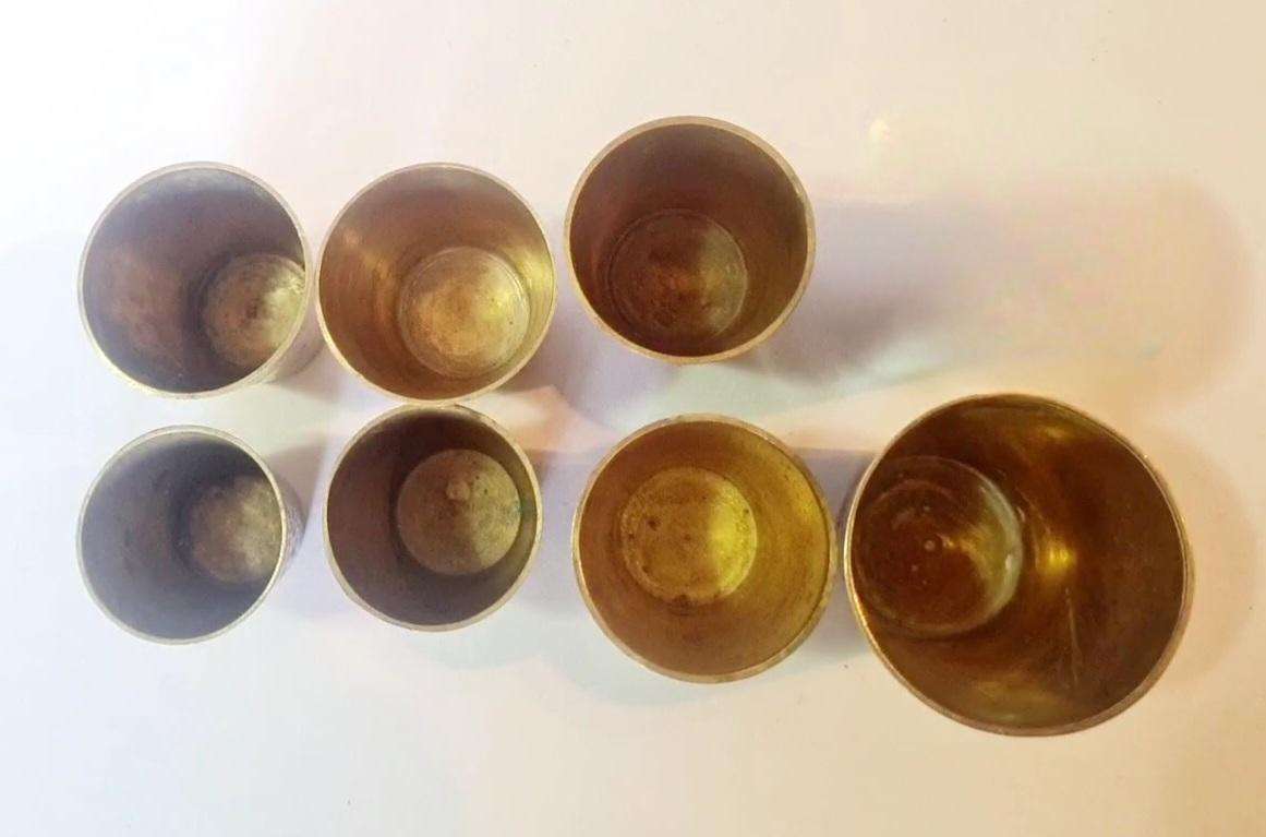 7 brass shot glasses. Various sizes