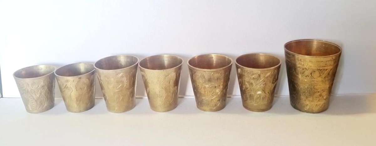 7 brass shot glasses. Various sizes