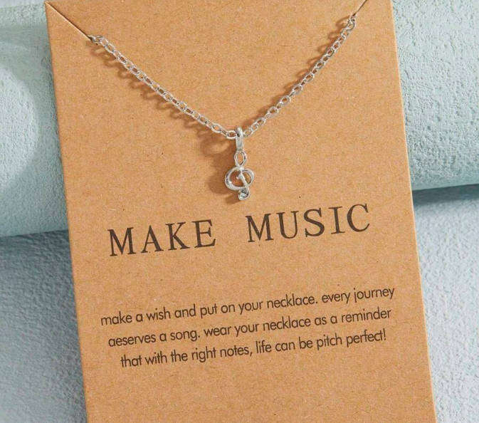 Music note pendant and chain on motivational card