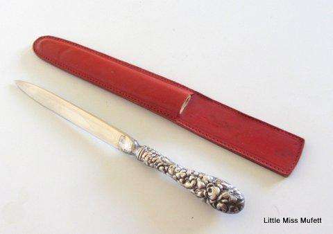 A fairly large sterling silver letter opener in a leather cover-- Sterling silver handle