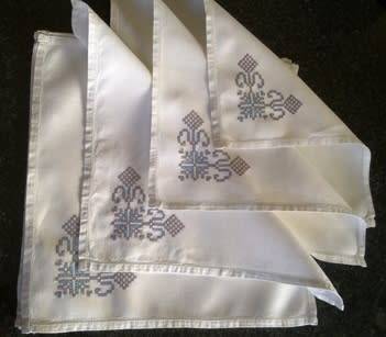 Ten hand embroidered white linen dinner serviettes