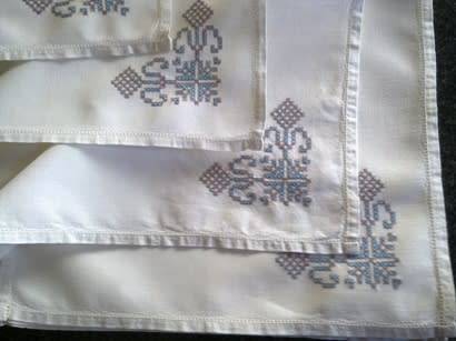 Ten hand embroidered white linen dinner serviettes