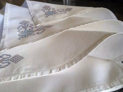 Ten hand embroidered white linen dinner serviettes