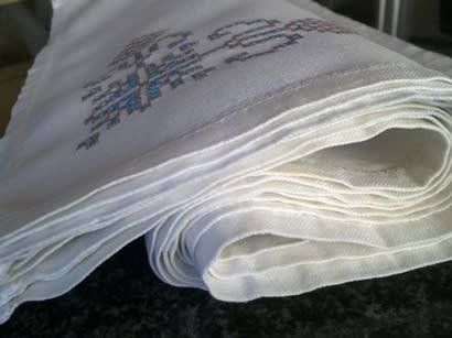 Ten hand embroidered white linen dinner serviettes