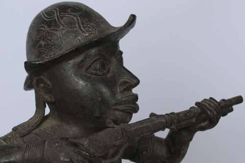 Brass figure of a Portuguese soldier holding a musket - Benin Nigeria