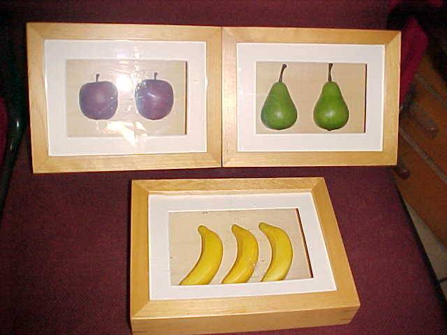 THREE FRUIT PICTURES IN WOODEN FRAME BEHIND GLASS