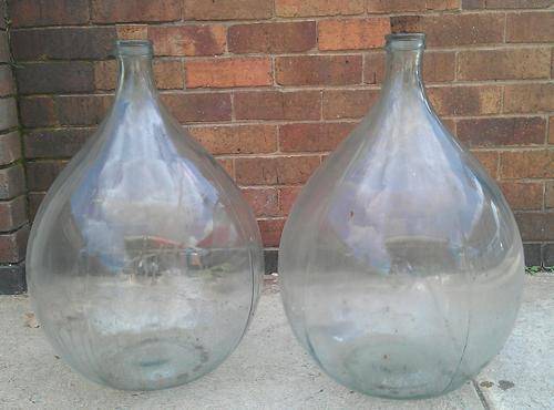 large glass demijohns carboys in plastic carriers