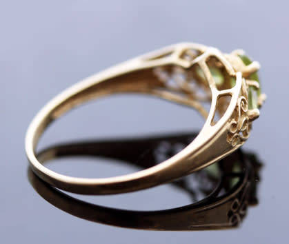 UNUSUAL VINTAGE PERIDOT 9CT YELLOW GOLD RING WITH OPENWORK SCROLL DETAILS. 375