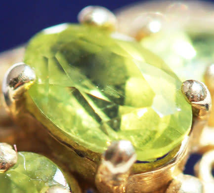UNUSUAL VINTAGE PERIDOT 9CT YELLOW GOLD RING WITH OPENWORK SCROLL DETAILS. 375