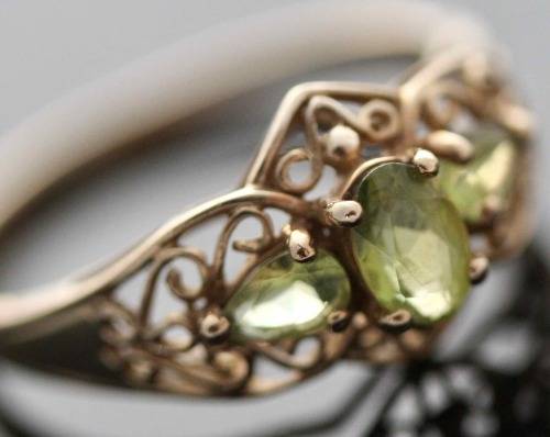 UNUSUAL VINTAGE PERIDOT 9CT YELLOW GOLD RING WITH OPENWORK SCROLL DETAILS. 375