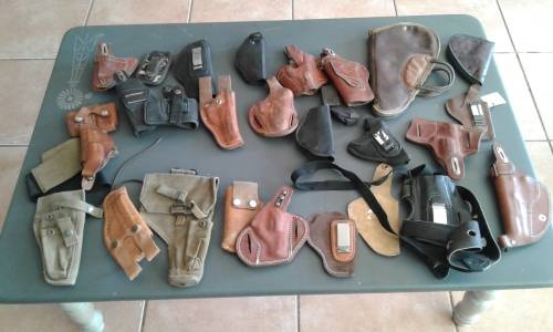COLLECTION OF 28 PISTOL/ REVOLVER HOLSTERS. WIDE ASSORTMENT. ONE BID..