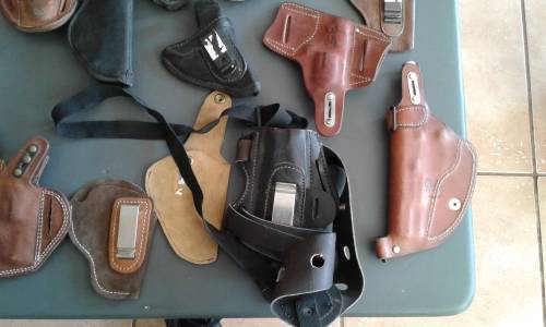 COLLECTION OF 28 PISTOL/ REVOLVER HOLSTERS. WIDE ASSORTMENT. ONE BID..
