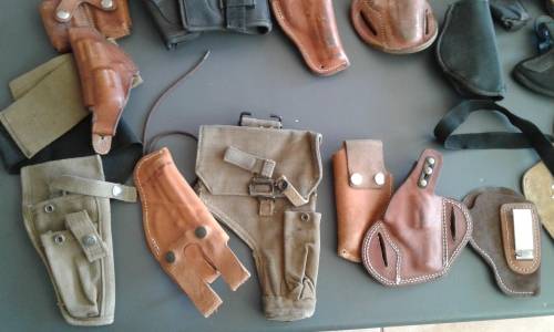 COLLECTION OF 28 PISTOL/ REVOLVER HOLSTERS. WIDE ASSORTMENT. ONE BID..