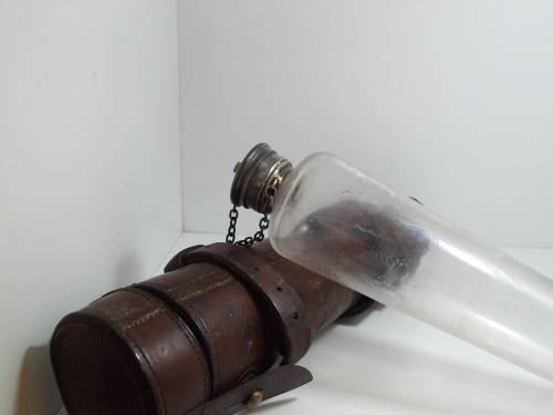 Antique saddle flask glass with leather holder.
