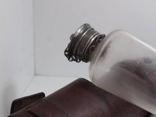 Antique saddle flask glass with leather holder.