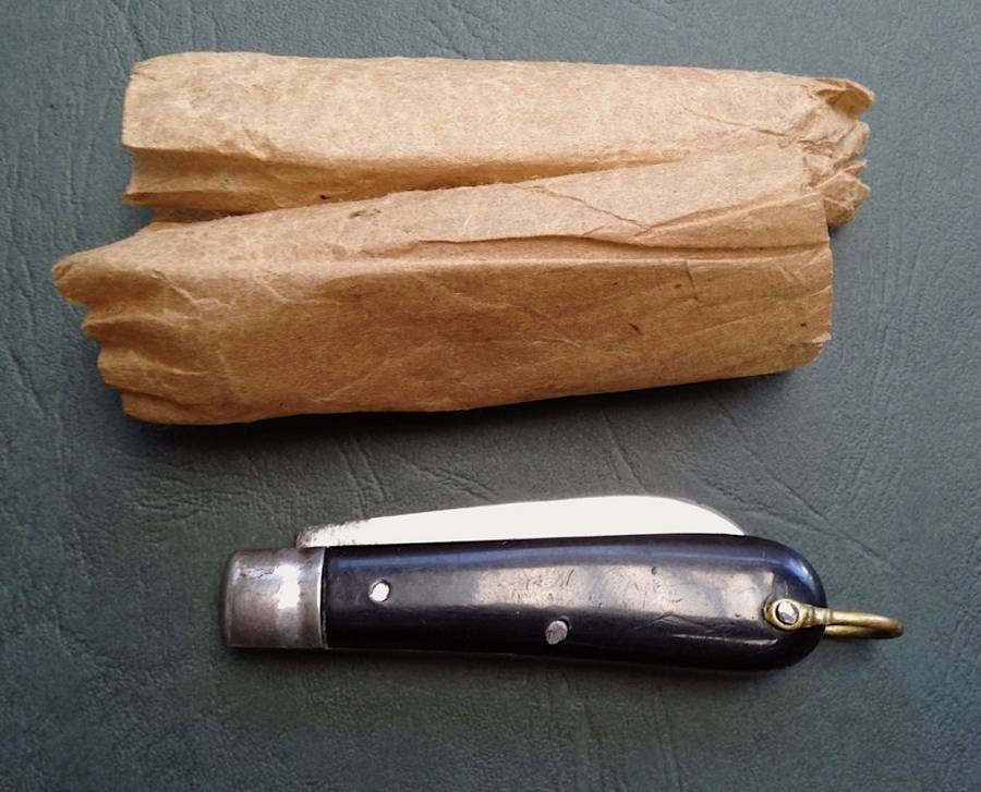 Vintage carbon steel pocket knife, unused in original brown paper wrapping.