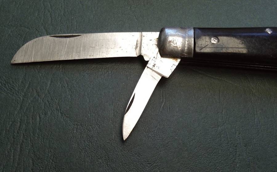 Vintage carbon steel pocket knife, unused in original brown paper wrapping.