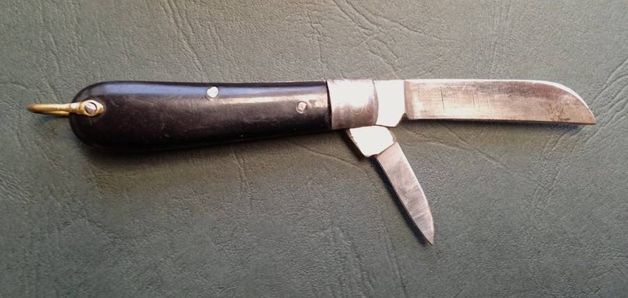 Vintage carbon steel pocket knife, unused in original brown paper wrapping.