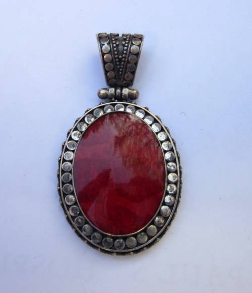 Red coral set in a beautifully decorative sterling silver hinged pendant.