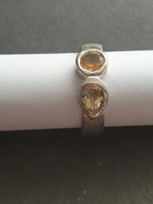 A siver ring with pink stons one rond and one teardrop the ring is stamp 925