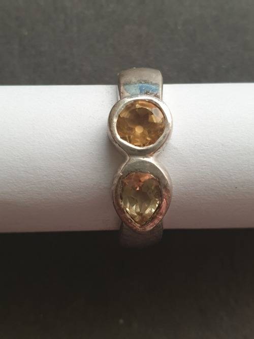 A siver ring with pink stons one rond and one teardrop the ring is stamp 925