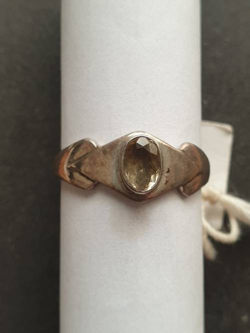 A siver ring with yellow stones cushion cut stone