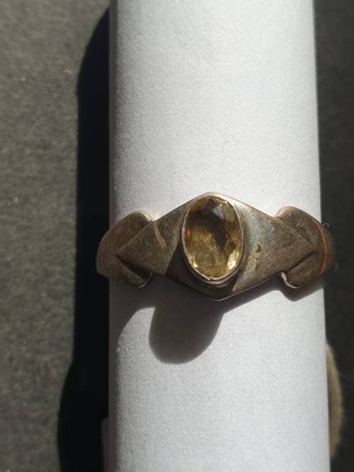 A siver ring with yellow stones cushion cut stone