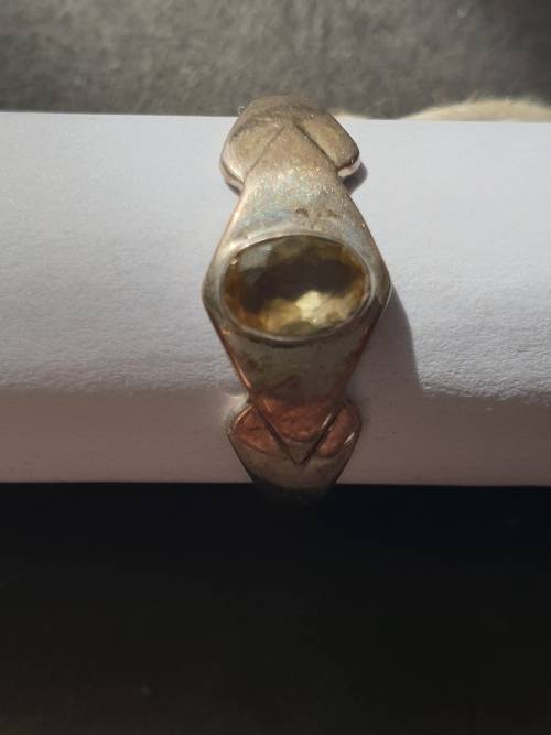 A siver ring with yellow stones cushion cut stone
