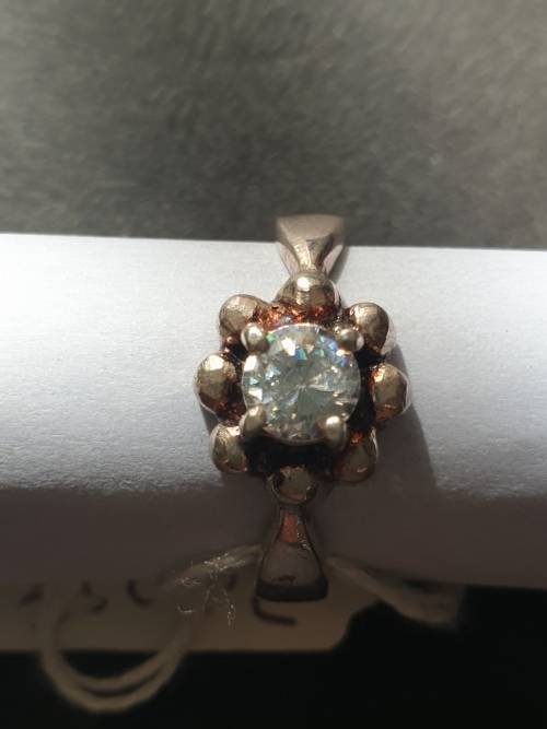 A siver ring with white stones round cut stone