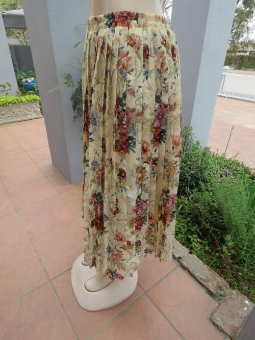 Permanent pleated silky polyester skirt in beige with colourful floral pattern.Size 40/16