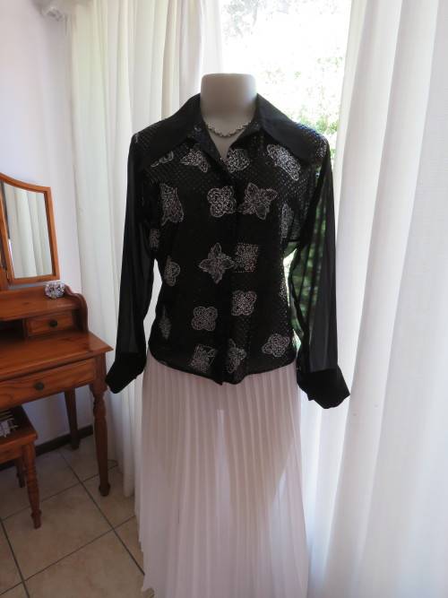 Glamorous black ELEGANCE blouse in sheer polyester back and long cuffed sleeves.Size 36/12