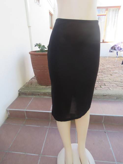 Trendsetting black stretch polyester skirt with high/low seam in 34/10.In good condition.