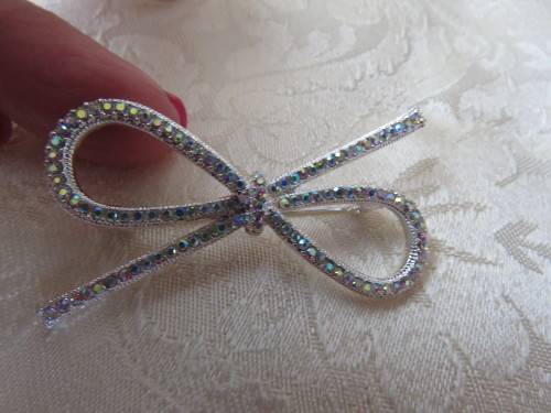 Silver toned bow design brooch with small glimmer stones.Length 5.2cm.New item.