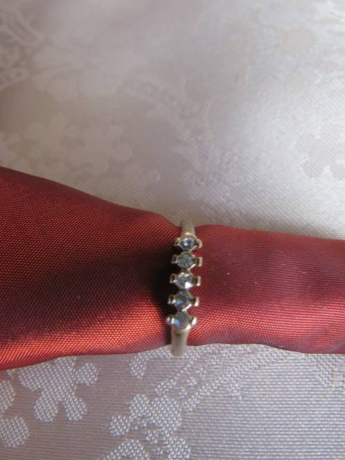 Dainty gold toned ring in size 8 with 5 simulated diamond stones.New ring.