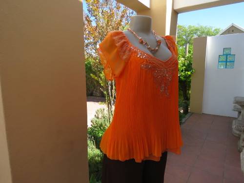 Pretty orange colour top in size 36/12 by 'W2'.Top layer in permanent pleats.Used but in good cond.